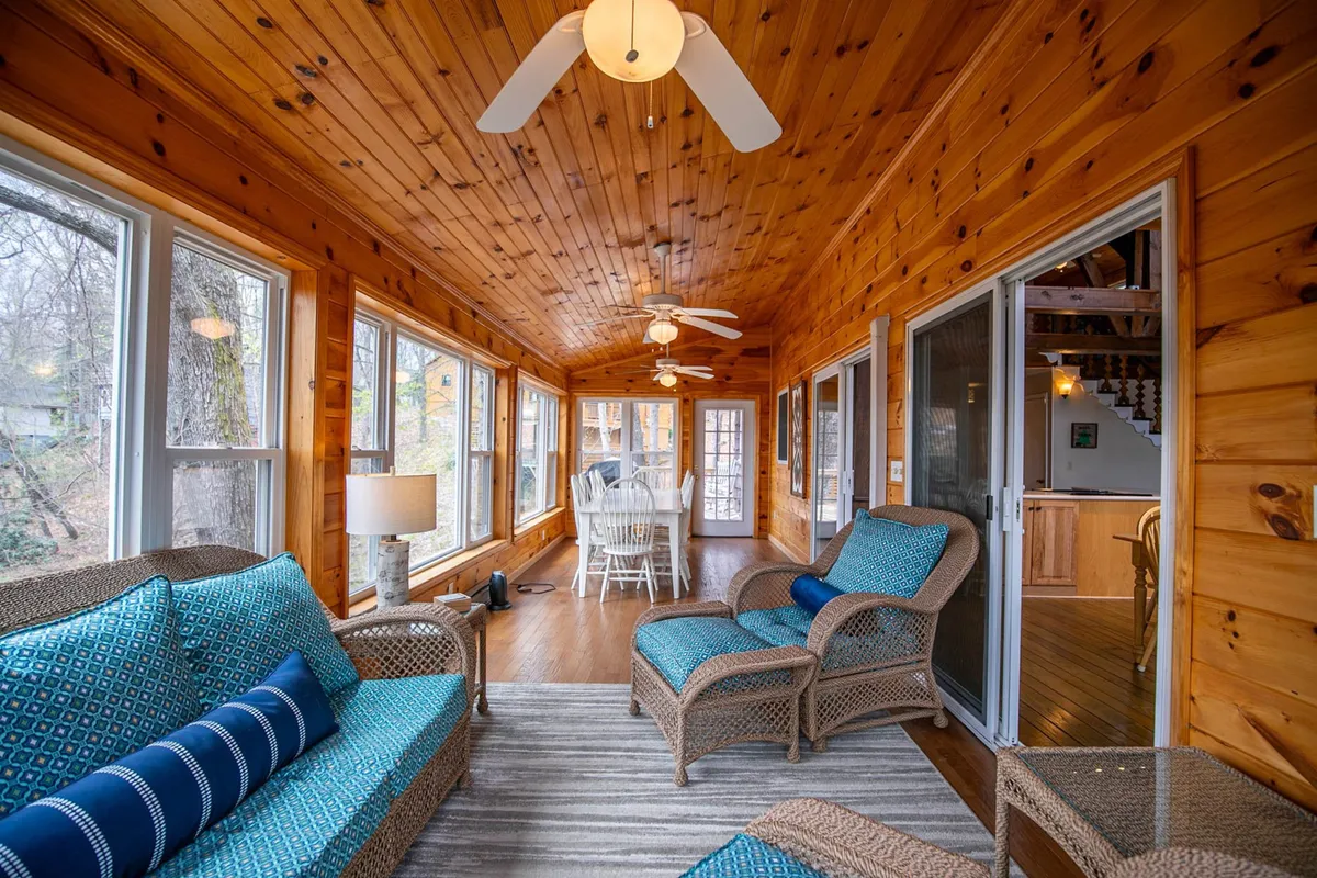 Featuring woven furniture and large windows that allow natural light to pour in, this comfortable room is designed for relaxation and socializing. The light fixture and welcoming mood make it ideal for sunlit breakfasts or cozy evening gatherings, reflecting the flexible uses emphasized in the section.